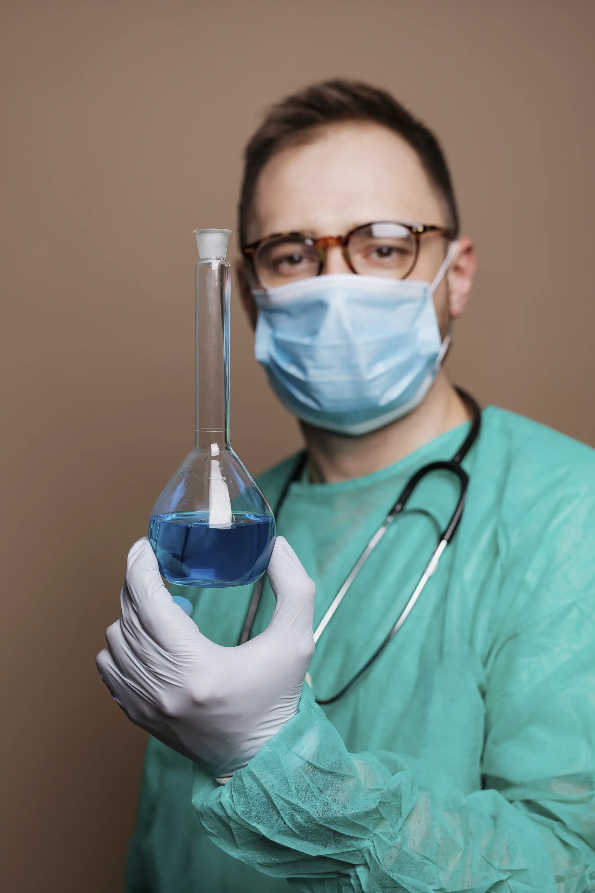 Profesional del laboratorio Labmas sosteniendo un matraz con reactivo